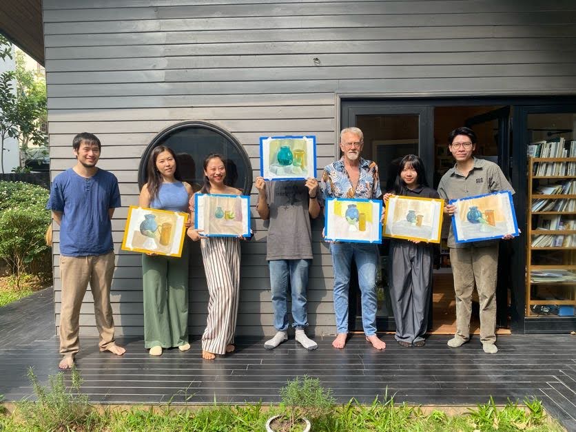 a group of 7 people including an art teacher posing with their oil painting work as result of a Last-Minute Art Class for Your Free Day